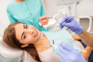 A woman is getting her teeth cleaned in a dentist's office.