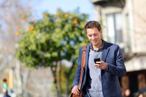 A man in a suit is looking at his cell phone.